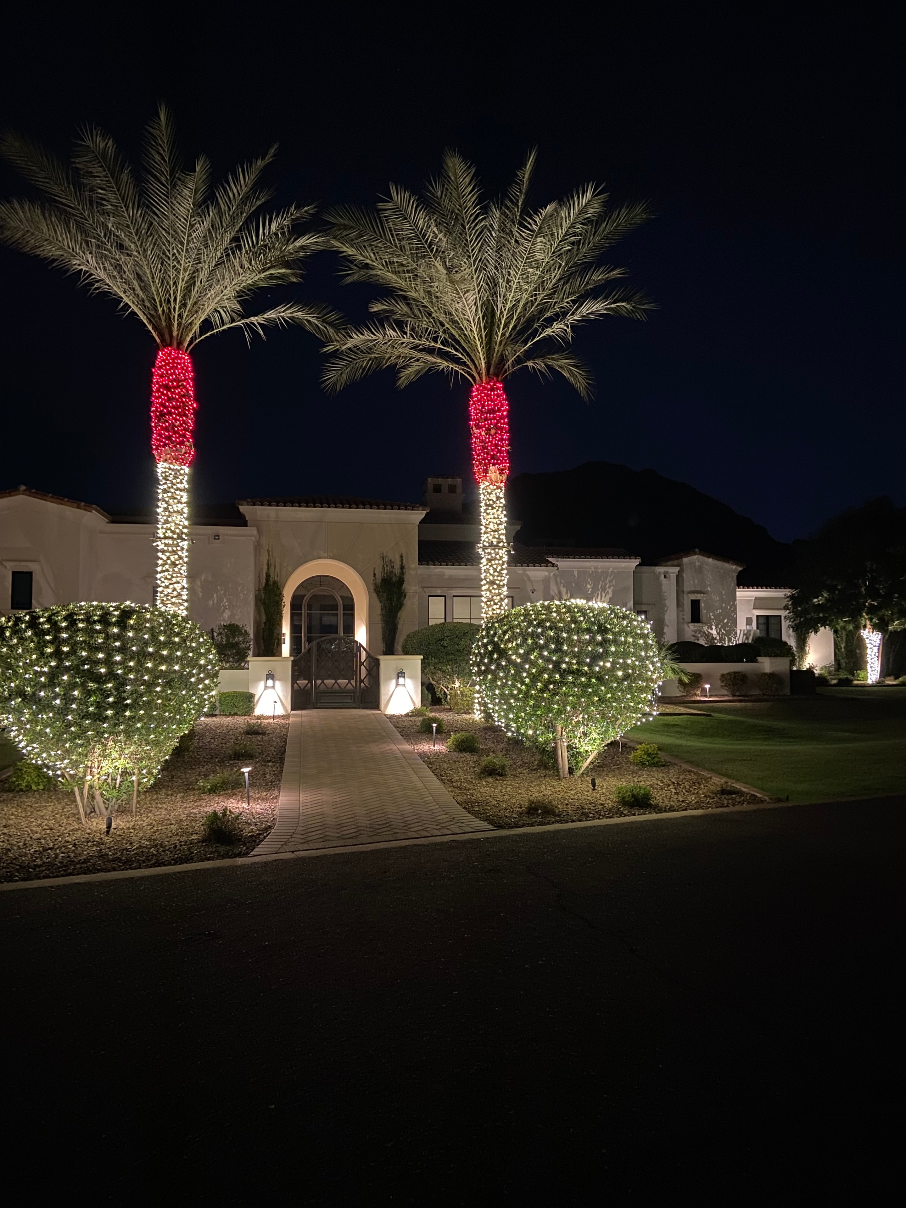 Mediterranean style estate decorated with multicolor holiday lights and glowing light orbs